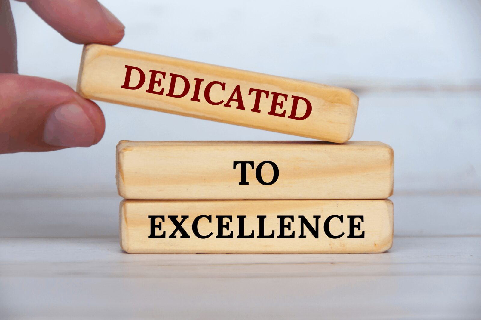 Wooden blocks spell out 'Dedicated To Excellence', representing one of the core values at Career Calling International.