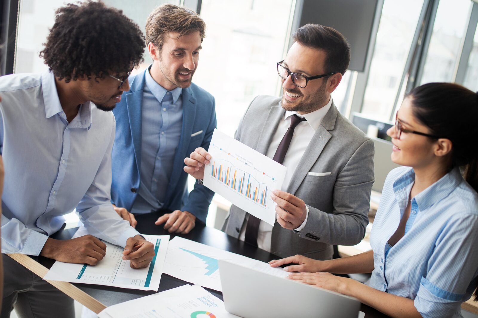 A diverse team collaborates reviewing business data, supporting quality vet compliance.