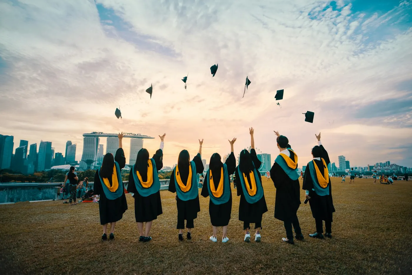 Graduation Celebration | Career Calling International Graduates celebrate their achievement throwing caps in the air, representing successful vocational education training.