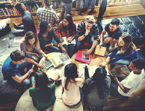 Students collaborate and learn in a university library, demonstrating effective VET compliance.