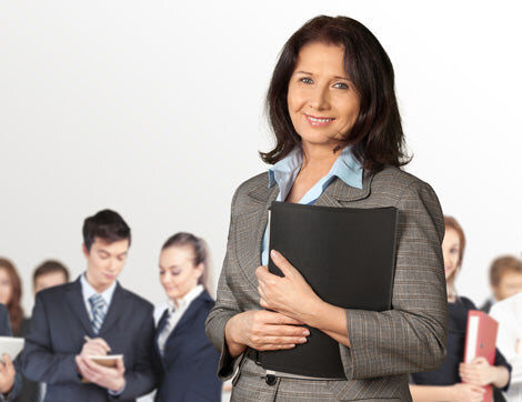 A businesswoman leads a team of office workers, showcasing Career Calling International's commitment to quality assurance.