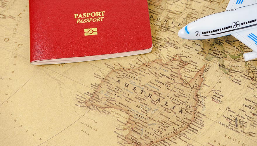 A red passport and toy airplane sit on a map of Australia, representing international student travel for vocational.
