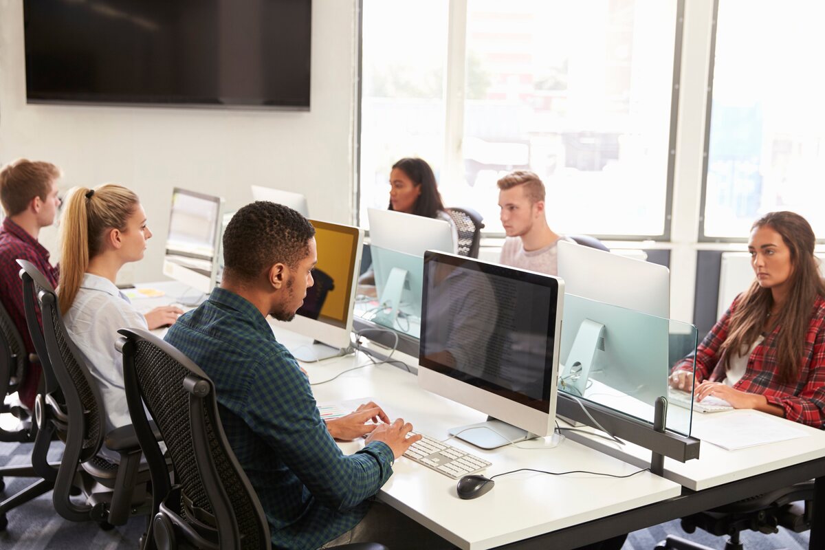 Diverse coworkers collaborate at computers, showcasing Career Calling International’s commitment to quality training.