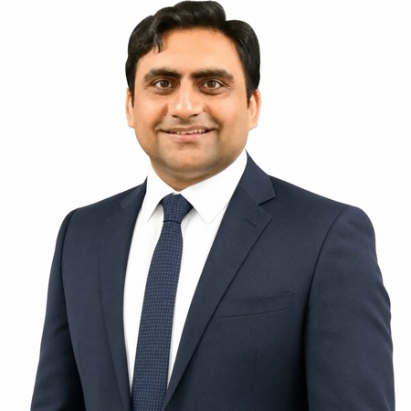 Sukh Sandhu, a business professional, smiles at the camera.